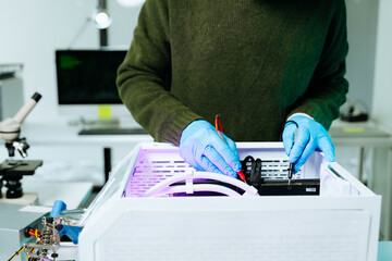 Capture the detailed work of a technician repairing a computer with a multimeter and blue gloves. Perfect for tech repair, electronics maintenance, and diagnostics themes.