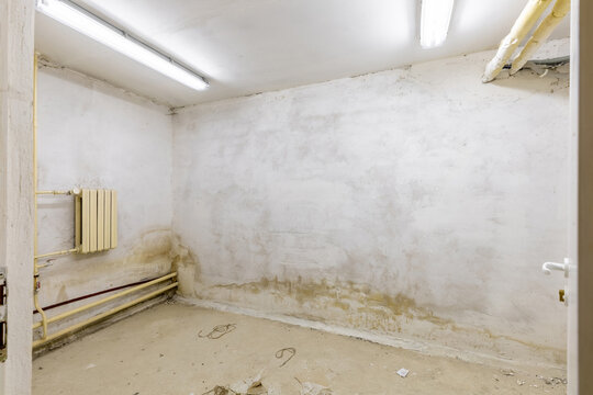 Old Basement Room with Worn Walls and Heating Pipes
