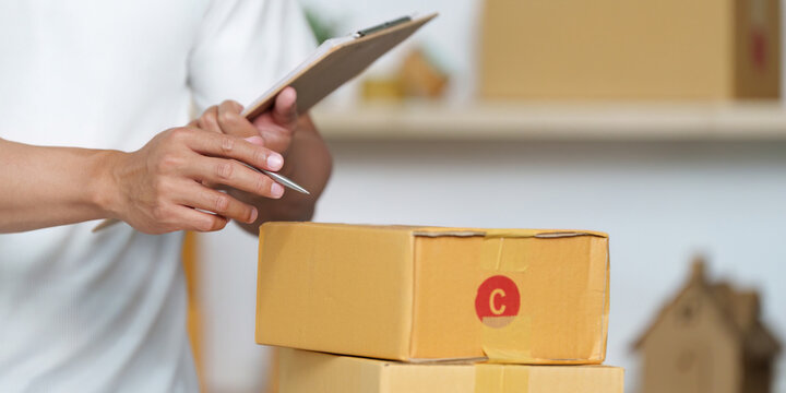 Inventory Management. Person checking packages with a clipboard, ensuring accuracy in logistics.