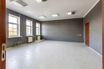 Empty Office Room with Grey Walls and Bright Windows