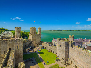 Obraz premium Aerial view of the Outer Ward of Caernarfon Castle and the blue Menai Strait (Caernarfon, Wales, United Kingdom)