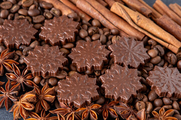 Christmas sweet food background. Coffee beans, cinnamon sticks, anise stars and chocolate candies top view.