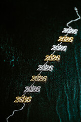 Several necklace pendants made of gold and silver with glittering zirconia, strung on a silver chain, numbers 2026 for the New Year's Eve celebration