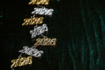 Several necklace pendants made of gold and silver with glittering zirconia, strung on a silver chain, numbers 2026 for the New Year's Eve celebration