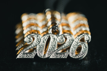 Several necklace pendants made of gold and silver with glittering zirconia, strung on a silver chain, numbers 2026 for the New Year's Eve celebration