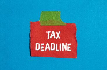Tax deadline message written on ripped torn paper background. Conceptual Tax deadline symbol. Copy...