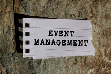 Event Management message written on ripped torn lined paper piece on stone background. Conceptual...