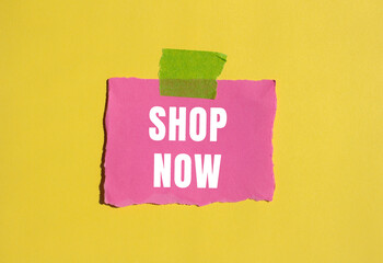 Shop Now message written on ripped torn paper background. Conceptual Shop Now symbol. Copy space.