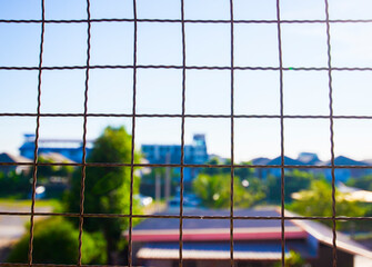 wire mesh fence with city view background, selective focus and copy space