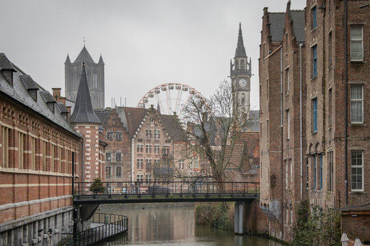 Traditional brick and stone architecture buildings along a canal in Ghent Belgium. Photo taken on a cloudy day