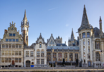 Famous waterfront view of the traditional architecture buildings and clock tower along the Graslei canal. Photo taken in Ghent Belgium on a cloudy day
