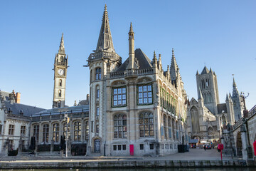 Obraz premium Famous waterfront view of the traditional architecture buildings and clock tower along the Graslei canal. Photo taken in Ghent Belgium on a cloudy day