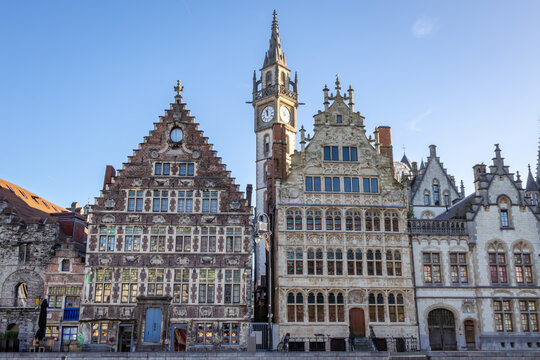 Famous waterfront view of the traditional architecture buildings and clock tower along the Graslei canal. Photo taken in Ghent Belgium on a cloudy day