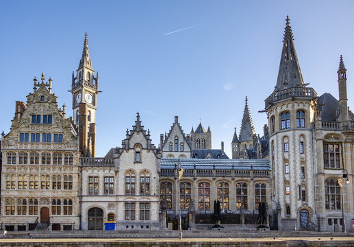 Famous waterfront view of the traditional architecture buildings and clock tower along the Graslei canal. Photo taken in Ghent Belgium on a cloudy day