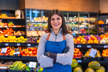 Woman working in supermarket grocer department smiling