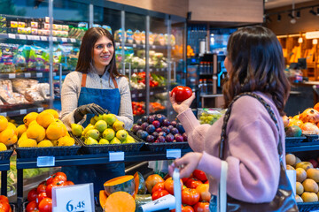 Employee helping customer buying organic fresh produce