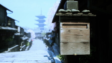 A rustic wooden mailbox awaits visitors along a peaceful stone pathway. Cherry blossoms adorn the buildings, while ancient pagodas rise in the background, evoking tranquility.
