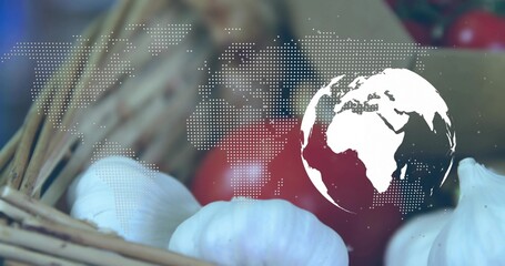 Showing garlic bulbs in basket on table, with red tomatoes, dotted world map, white globe icon