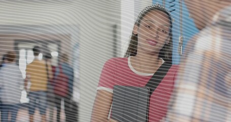 Leaning teen student holding gray binder, wearing pink tee and bag strap by blue school lockers