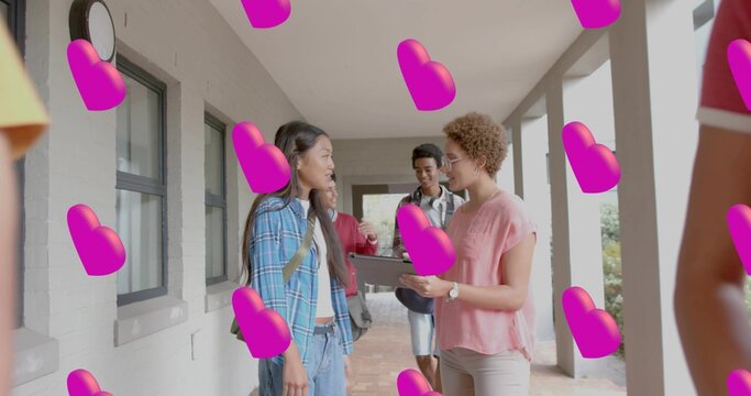 Talking student in blue plaid shirt and tutor holding tablet in school corridor, pink hearts