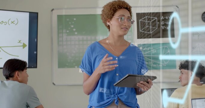 Holding tablet teacher in blue top light pants gesturing speaking at school with screen AR overlays