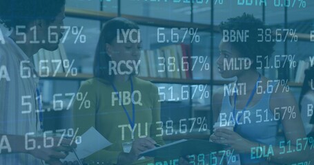 Standing five staff wearing lanyards in meeting, holding notes tablet cup pages under stock tickers