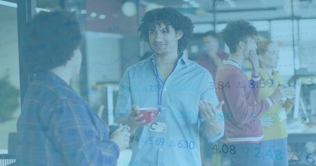 Gesturing curly man wearing blue shirt and lanyard holding red mug in open office, data overlay