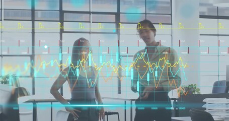 Analyzing female and male in turtleneck reviewing candlestick charts on glass wall in modern office