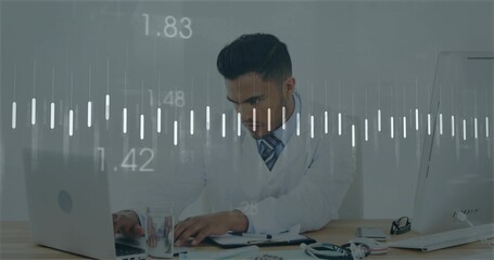 Working adult doctor in white lab coat leaning forward at clinic desk, with laptop and stethoscope