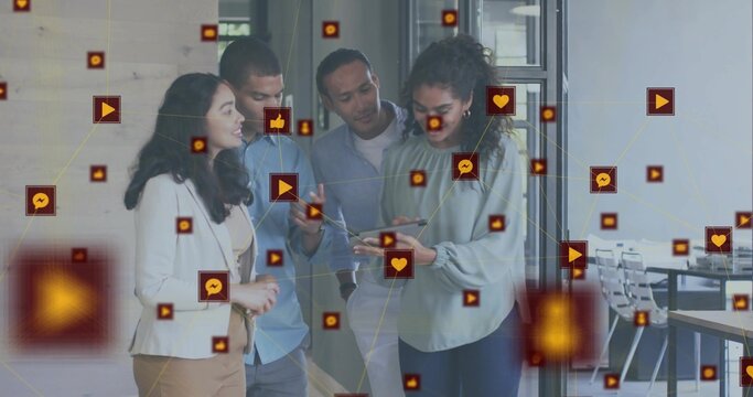 Gathering four business casual professionals viewing tablet in office corridor, with digital icons