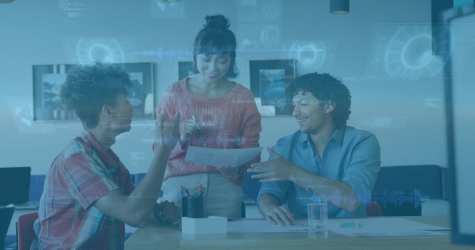 Presenting woman in coral sweater pointing at documents at office meeting table, with HUD overlay