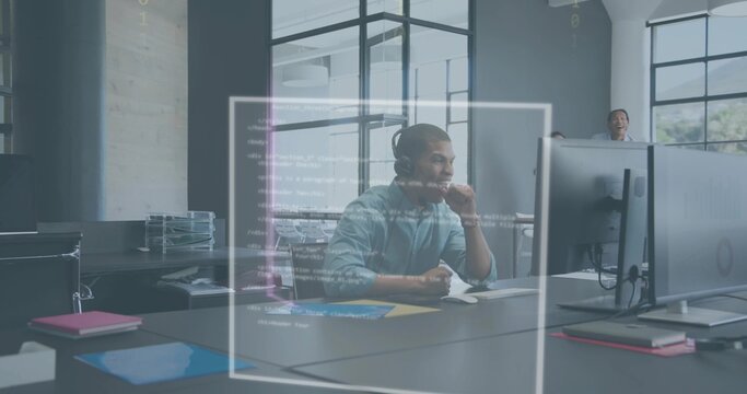 Reviewing developer wearing headset and light shirt debugging code on large monitor in open office - Powered by Adobe