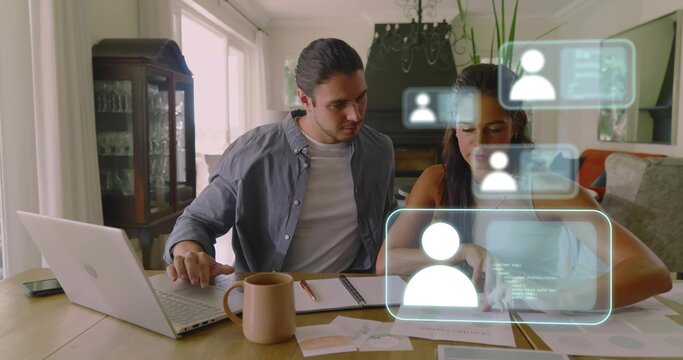 Reviewing couple collaborating at home wood table, using laptop, documents and holographic UI
