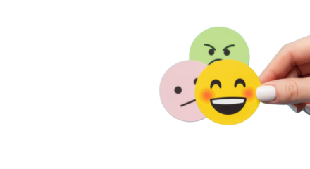 Close-up of a caucasian hand holding a bright yellow smiling emoji, with subtle pink neutral and green angry emojis in background, on light blue for customer feedback and satisfaction concept