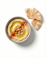 Homemade Hummus Bowl with Olive Oil and Pita Bread Isolated on White Background | Top View of Healthy Mediterranean Chickpea Dip with Paprika and Pine Nuts