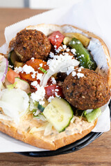 Falafel pita sandwich with feta cheese and fresh vegetables