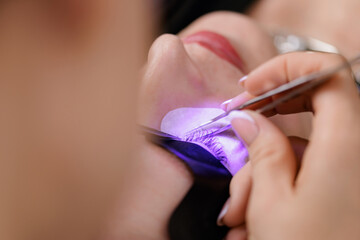 Led Eyelash extension application on female adult under uv light enhancement