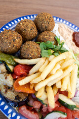 Falafel plate with fries, hummus, and vegetable salad