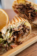 Cutting a doner kebab wrap on wooden board