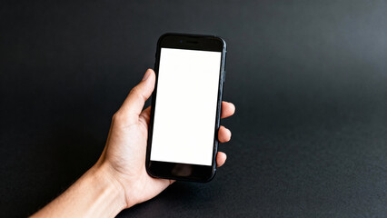 Hand holding smartphone with blank white screen on dark background for app, UI, branding or digital mockup  
