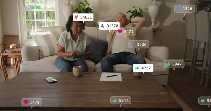 Woman picking up tablet and tapping, generating floating notifications around couple for tech demo