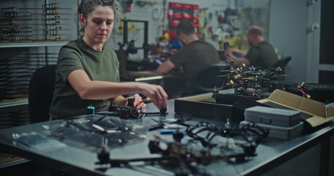 Military Grade Drone Assembly By Focused Female Defense Worker. Woman Assembling Military Grade FPV Drones. Concept of Facility Dedicated Defense Technology and Security Innovation. Dolly Shot.