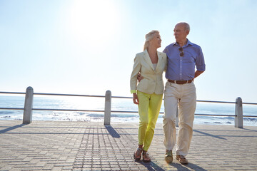Hug, travel and senior couple at sea, love and space on promenade outdoor. Elderly man, woman and holiday for romantic getaway, walk and embrace with smile in retirement together for ocean vacation