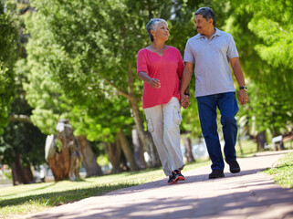 Fototapeta premium Holding hands, smile and walking with old couple in park for connection, bonding and retirement. Support, marriage milestone and commitment with senior man and woman outdoor for trust and low angle