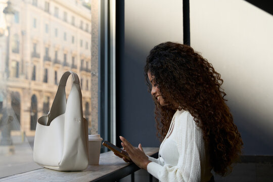 Woman using phone in coffee shop, connecting