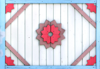 Vintage wooden shutter with peeling paint and rustical naive handmade decor. Retro wood door with simple hand-carved decor