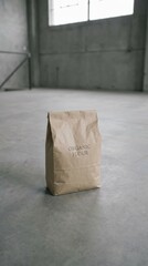 Brown paper bag labeled organic flour stands prominently on a concrete floor in a spacious industrial setting, showcasing minimalist design and natural product appeal