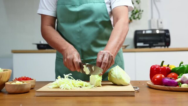Slicing fresh cabbage and vegetables for a healthy meal prep, showcasing cooking skills with organic ingredients and kitchen tools for a delicious and nutritious recipe.