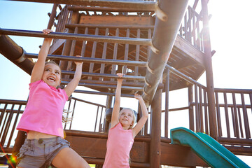 Happy girl, children and hanging with monkey bars for playful childhood or fun outdoor summer. Kid, friends or climbing on jungle gym for youth, development or playing game at park or playground