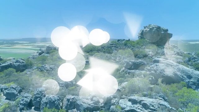 Graphic shapes appearing from left center drifting over ridge with drone panning revealing plains